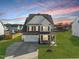 Two-story home featuring a two-car garage, and a well manicured front yard during a beautiful sunset at 140 Southern Acres Dr, Fuquay Varina, NC 27526