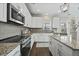 Well-lit kitchen with stainless steel appliances, granite countertops, and ample cabinet space at 140 Southern Acres Dr, Fuquay Varina, NC 27526