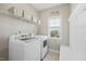 Functional laundry room with washer, dryer, storage shelves, and a convenient folding bench at 140 Southern Acres Dr, Fuquay Varina, NC 27526