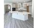 This kitchen features a spacious island with light countertops, stainless appliances, and ample storage in a modern design at 142 Oban Dr, Homesite 135, Sanford, NC 27330