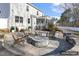 Backyard featuring a stone patio with fire pit, chairs, and a view of the house at 192 Springhill Ln, Garner, NC 27529