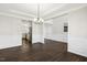 Spacious dining room with dark wood floors, white wainscoting, and modern light fixture at 192 Springhill Ln, Garner, NC 27529
