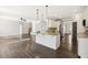 Open kitchen with granite island, white cabinets, and stainless steel appliances flows into living area at 192 Springhill Ln, Garner, NC 27529
