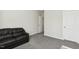 Living room with a black leather sofa, gray carpet, and neutral paint at 192 Springhill Ln, Garner, NC 27529