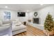 Cozy living room featuring a fireplace, soft sectional sofa, and a Christmas tree, perfect for Gathering gatherings and entertainment at 217 Northfield Dr, Raleigh, NC 27609