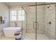 This bathroom features a modern tub, glass shower, and a window that provides ample natural light at 25 Blackhorn Ct, Pittsboro, NC 27312