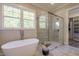 The bathroom features a modern tub, glass shower, and a window that provides ample natural light at 25 Blackhorn Ct, Pittsboro, NC 27312