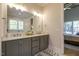 This bathroom features a double sink vanity, a well lit mirror, and access to the Primary bedroom at 25 Blackhorn Ct, Pittsboro, NC 27312
