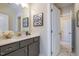 Stylish bathroom featuring gray vanity, framed mirror, and adjacent door at 25 Blackhorn Ct, Pittsboro, NC 27312