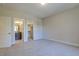 Large carpeted bedroom featuring doorways to closet and bathroom at 25 Blackhorn Ct, Pittsboro, NC 27312