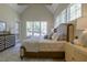 A luxurious bedroom featuring a tray ceiling, multiple windows, and stylish furniture at 25 Blackhorn Ct, Pittsboro, NC 27312