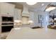 Close up of a well-lit kitchen featuring white cabinets, quartz countertops, and modern appliances at 25 Blackhorn Ct, Pittsboro, NC 27312