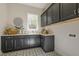 Well-lit laundry room features ample counter space, stylish cabinetry and eye-catching patterned floor tiles at 25 Blackhorn Ct, Pittsboro, NC 27312