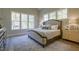 Serene main bedroom featuring multiple windows, light wood floors, elegant furnishings, and soothing color palette at 25 Blackhorn Ct, Pittsboro, NC 27312