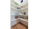 Walk-in pantry with custom shelving for organized storage of food items and cooking essentials, plus wood flooring at 25 Blackhorn Ct, Pittsboro, NC 27312