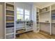 A walk-in closet with custom shelving and storage, illuminated by a window providing natural light at 25 Blackhorn Ct, Pittsboro, NC 27312