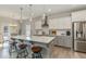 Bright kitchen boasts a large island with marble countertops, pendant lighting, and white and gray cabinetry at 25 Courrone Ct, Willow Springs, NC 27592