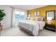 Bright bedroom showcases a king-size bed, large window, and stylish decor against a yellow accent wall at 251 Perseus St, Angier, NC 27501