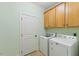 Laundry room with cabinets, tile floor, and modern washer and dryer units at 27 Fairwoods Dr, Durham, NC 27712