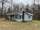 Side view of a quaint single-story house with a chimney and covered porch at 3115 Woods Chapel Rd, Graham, NC 27253