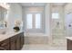 Elegant bathroom with marble tiling, soaking tub, separate shower, and dual vanity sinks at 328 Conner Ridge Rd, Efland, NC 27243