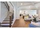 Open living space with staircase, hardwood floors, and kitchen view in neutral color palette at 328 Conner Ridge Rd, Efland, NC 27243