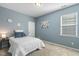 Cozy bedroom featuring a bed with blue pillows, a side table, and a bright window at 3333 Sandy Meadows Dr, Fuquay Varina, NC 27526