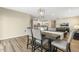 Dining area with a wooden table set for six, adjacent to a modern kitchen and living room space at 3333 Sandy Meadows Dr, Fuquay Varina, NC 27526