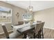 Dining area with a wooden table set for six under a chandelier, illuminated by a window with blinds at 3333 Sandy Meadows Dr, Fuquay Varina, NC 27526