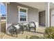 Relaxing front porch seating area with two wicker chairs, throw pillows, a side table, and shade at 3333 Sandy Meadows Dr, Fuquay Varina, NC 27526