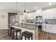 Stylish kitchen island featuring dark granite countertops, pendant lighting, seating, and stainless steel appliances at 3333 Sandy Meadows Dr, Fuquay Varina, NC 27526
