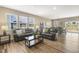 Comfortable living room featuring leather sofas, wood floors, and natural light from large windows at 3333 Sandy Meadows Dr, Fuquay Varina, NC 27526