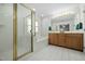 Bathroom features a glass-enclosed shower, soaking tub, vanity with dual sinks, and white tile flooring at 3648 Praed Pl, Fuquay Varina, NC 27526