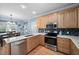 Bright kitchen boasts stainless steel appliances, light wood cabinetry, and a view into the dining area at 3648 Praed Pl, Fuquay Varina, NC 27526