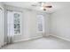 Bright bedroom with neutral paint, ceiling fan, and two windows dressed in sheer curtains at 4523 Hamptonshire Dr, Raleigh, NC 27613
