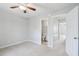 Neutral bedroom leading to bathroom and hallway with open door and ceiling fan at 4523 Hamptonshire Dr, Raleigh, NC 27613