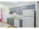 Well-lit kitchen with gray cabinets, granite countertops, white subway tile backsplash, and modern appliances at 4523 Hamptonshire Dr, Raleigh, NC 27613