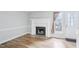 Bright living room with hardwood floors and a cozy fireplace with white mantle and gray tile at 4523 Hamptonshire Dr, Raleigh, NC 27613