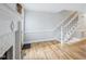 Cozy living room showcasing hardwood floors, chair railing, a staircase, and fireplace with white mantle at 4523 Hamptonshire Dr, Raleigh, NC 27613
