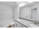 Bright bathroom featuring granite countertops and double sinks with a shower and bath combo at 46 Shay St, Angier, NC 27501