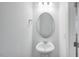This well-lit bathroom features a pedestal sink and a modern oval mirror, creating a clean aesthetic at 46 Shay St, Angier, NC 27501