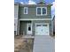 Two-story home with green siding, white trim, and a one-car garage with stone accents on the facade at 46 Shay St, Angier, NC 27501