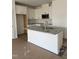 A modern kitchen features a granite island with a sink, complemented by white cabinets and stainless steel appliances at 46 Shay St, Angier, NC 27501