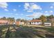 Backyard with lawn and detached shed, under a sunny sky with scattered clouds at 47 Angela Way, Durham, NC 27703
