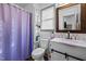 Bathroom featuring a shower with purple curtain, white vanity, and decorative shelving and mirror at 47 Angela Way, Durham, NC 27703