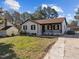 View of home with a detached garage and long driveway, surrounded by mature trees and greenery at 47 Angela Way, Durham, NC 27703
