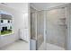 The bathroom has a tiled shower with bench and a white vanity with drawers and cabinets at 52 Shay St, Angier, NC 27501