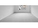 Neutral bedroom with gray carpet, white walls, and a large window overlooking the community at 52 Shay St, Angier, NC 27501
