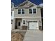 Charming townhome with a one-car garage, neutral siding, and stone accents on the facade at 52 Shay St, Angier, NC 27501