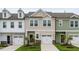 Attractive townhome showcases a neutral exterior, a one car garage, and manicured front lawn at 52 Shay St, Angier, NC 27501
